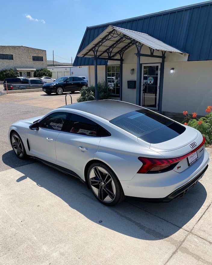 Silver Audi e-tron GT with tinted windows outside the Sunbusters shop