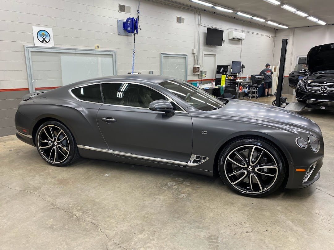 Grey Bentley in the bay, with the badge on the wall