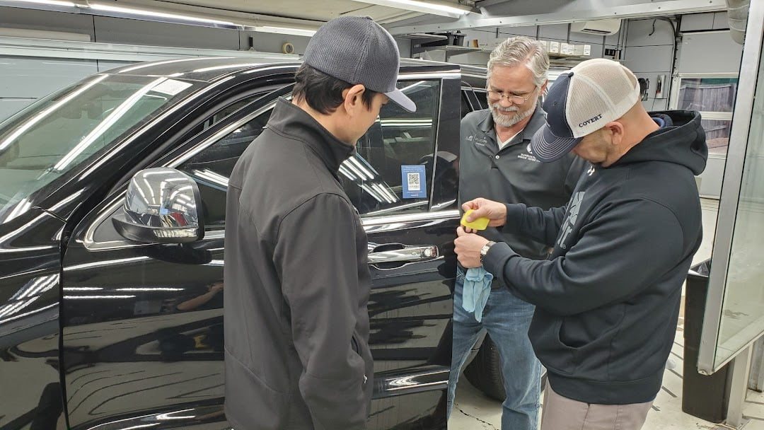 Three men checking a door panel