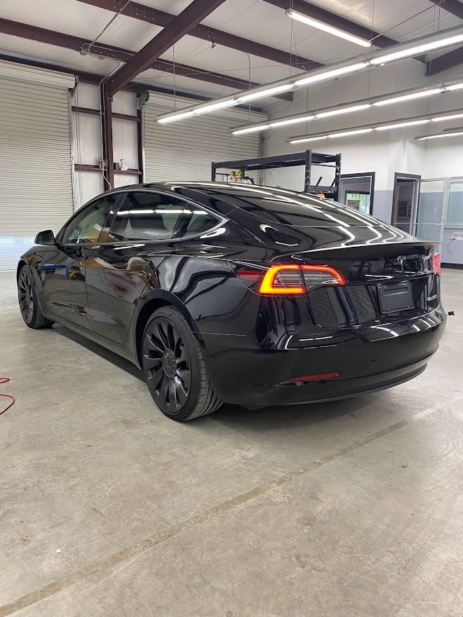 Black Tesla Model 3 with tinted windows in the bay