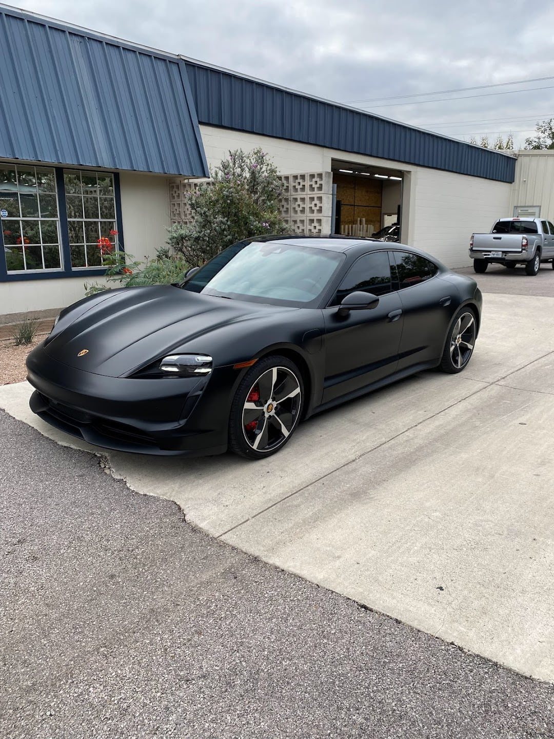 Black Porsche Taycan outside the shop